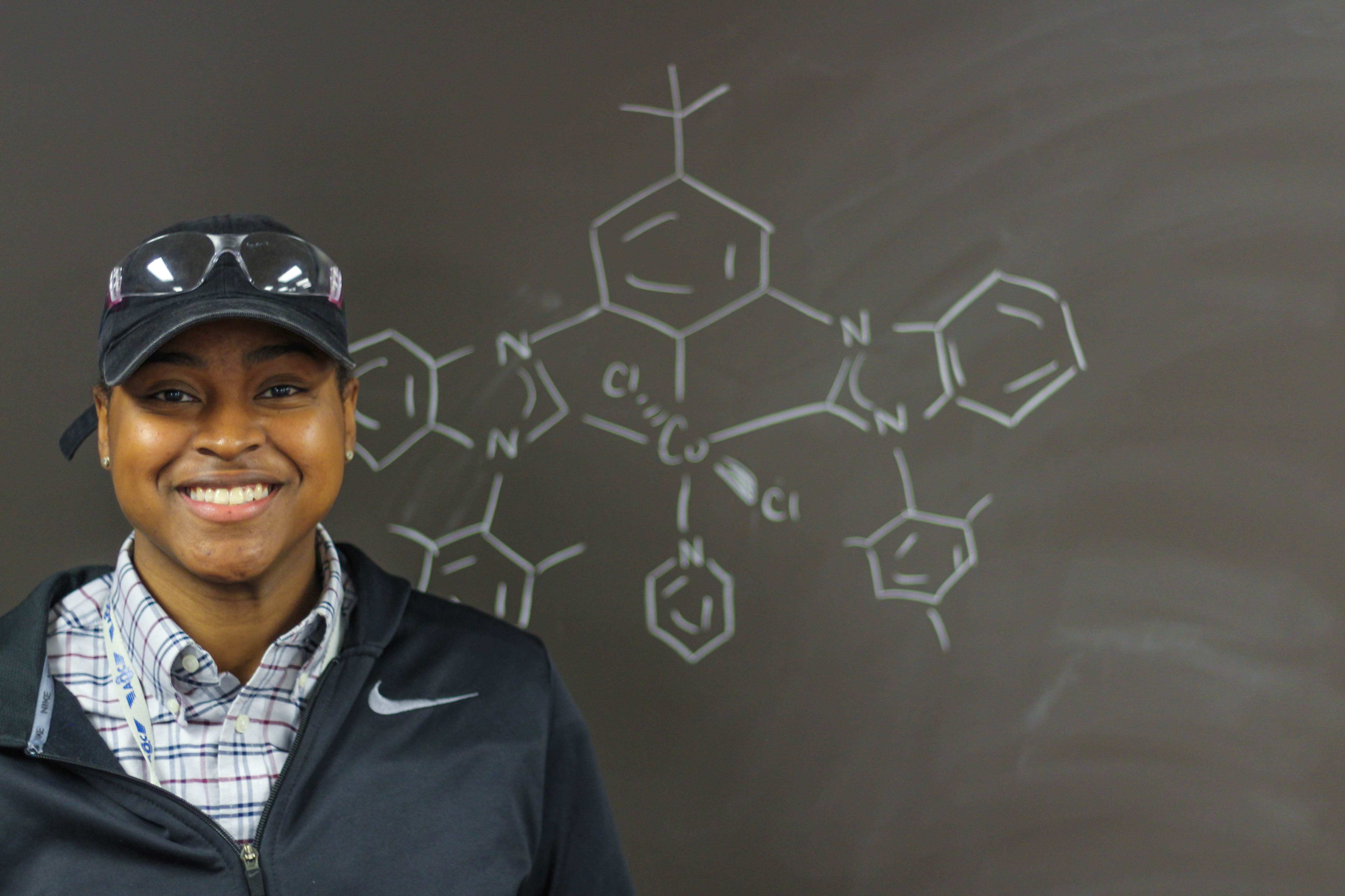 Safiyah Muhammad in front of a chalkboard with some writing on it