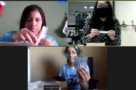 A computer screen shot shows graduate student Belinda Pacheco leading two middle schoolers in a chemistry demonstration.  