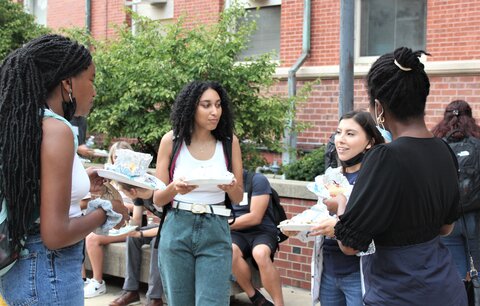 Students stand outside Noyes laboratory, talking during a C2 event.