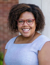 Portrait of Lauren Hagler with a brick and white background