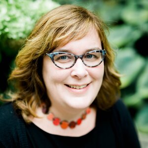 Head shot of Sara Skrabalak with foliage in background, glasses and black shirt