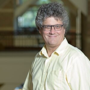 Head shot of Jonathan Sweedler in a button-down collared shirt in the atrium of a building