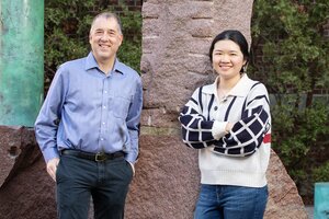 Photo of Andrew Gewirth in a blue button-down shirt standing next to graduate student Stephanie Chen in an outdoor photo on the UIUC campus 