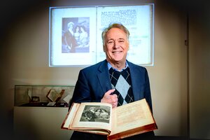 Photo of Greg Girolami standing behind an open book.