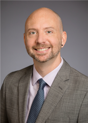 Portrait of Charles Schroeder on a gray background.