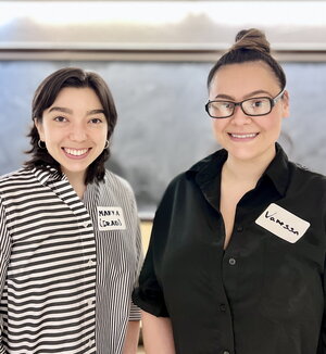 Portrait of Marya Ornelas standing next to Vanessa with a chalkboard in the background.