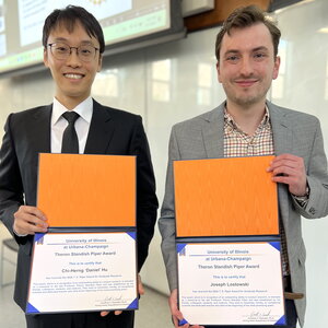 Daniel Hu and Joe Lastowski stand side by side holding award certificates in front of them.