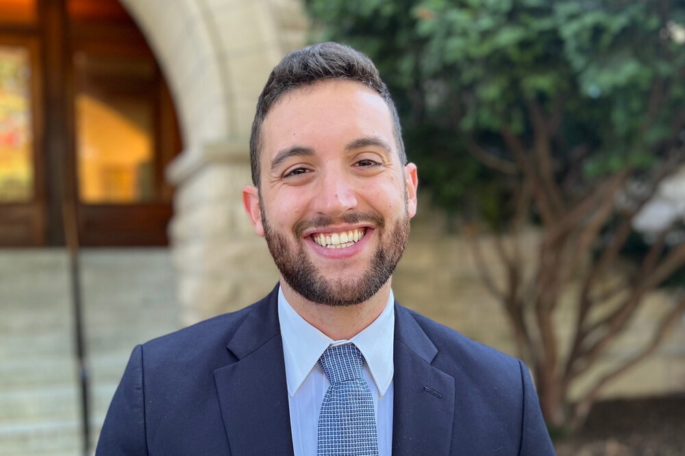 Head shot of Joe Forzano standing outdoors in front of the entrance to Noyes