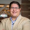 Head and shoulders photo of Joaquin Rodriguez Lopez smiling, looking into the camera wearing a sport coat and button-down shirt