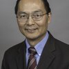 Head shot of Huimin Zhao on a gray background.