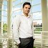 Portrait of Prashant Jain in the second floor atrium of a building with all windows in the background.