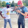 Lloyd Munjanja, on left, is pictured with a pool and people in the background as he assists Martin Gruebele, on right, who is in swimming gear.  