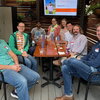 A group of event attendees sitting in chairs at a table in an outdoor venue