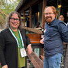 Catherine Murphy and stand with an event attendee in the outdoor venue