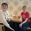 Two event attendees sit at a table indoors at the event venue