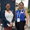 Two event attendees standing side by side in the outdoor venue